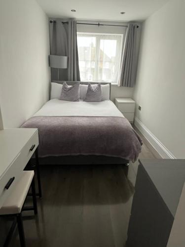 Un dormitorio con una cama grande y una ventana en Double Guest Room 40 minutes from Central London, en Chessington