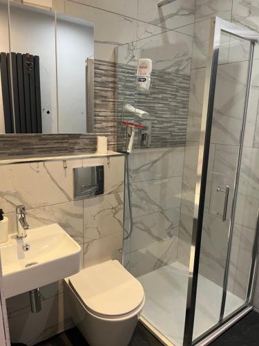 Un baño con ducha, inodoro y lavabo. en Double Guest Room 40 minutes from Central London, en Chessington