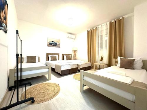 een grote kamer met 2 bedden en een bank bij LuxuryHomeUlcinj in Ulcinj