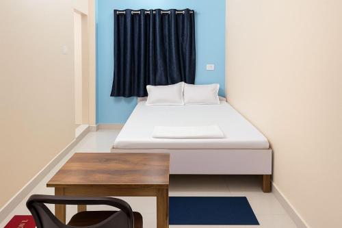 ブッダガヤにあるDev Residencyのベッドとテーブルのある小さな部屋