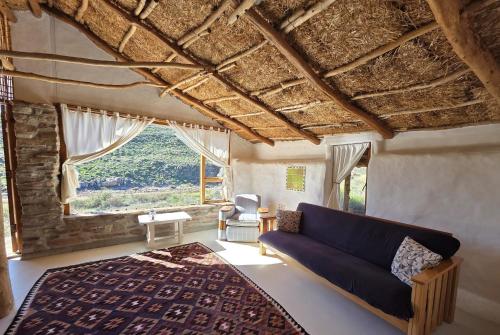 a living room with a couch and a large window at Oudrif Strawbale Retreat in Clanwilliam