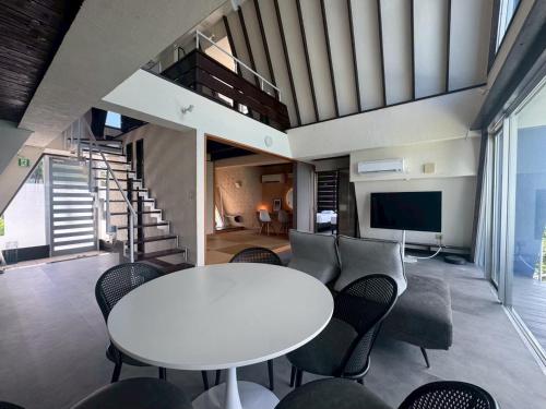 a living room with a white table and chairs at オーシャンフロントヴィラSerenity Point37 in Nakijin
