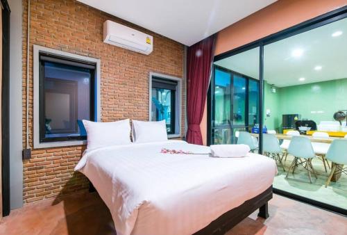 a bedroom with a large bed and a brick wall at Le Villa Huahin in Ban Khao Rang
