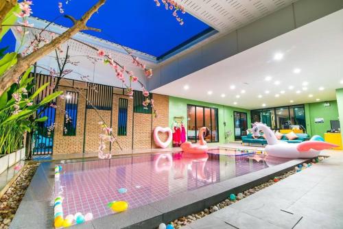 a pool with inflatable flamingos in a house at Le Villa Huahin in Ban Khao Rang
