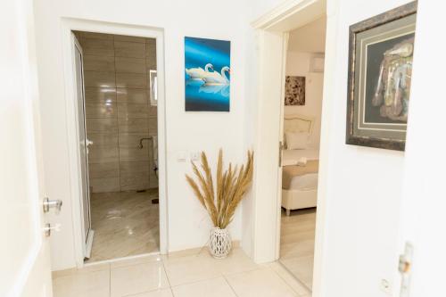 een badkamer met een vaas met een plant erin bij LuxuryHomeUlcinj in Ulcinj