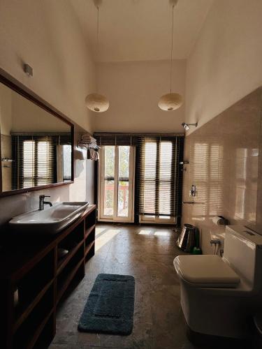 a bathroom with a sink and a toilet and a tub at Emerald Tiger Retreat in Tāla