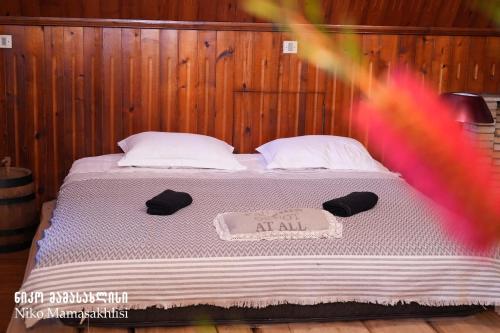 a bedroom with a bed with a sign on it at Niko Mamasakhlisi Guest House in Ozurgetʼi