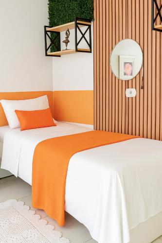a bedroom with two beds and a mirror at Mini Garden kitnet in Paranavaí