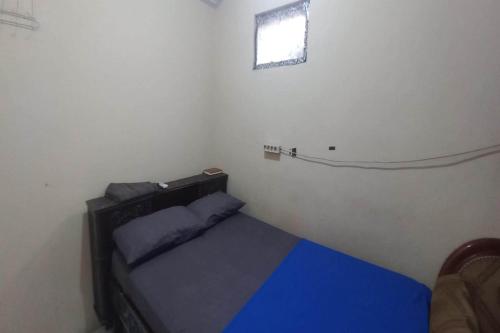 a small room with a bed and a window at Hotel O 94911 Syariah Anggrek Guest House in Lebakwangi