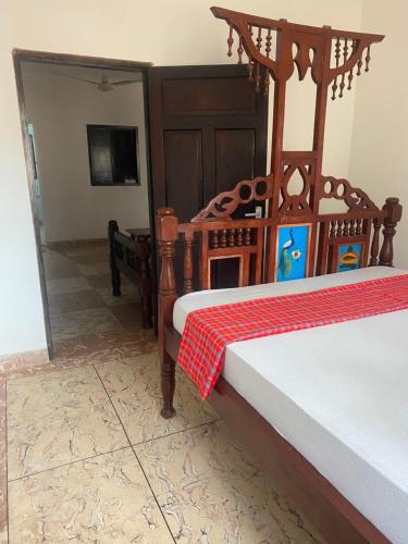 a bedroom with a bed with a red and white blanket at MK Casa Modern 3BR Retreat Fully Furnished in Malindi