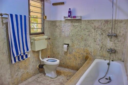 a bathroom with a toilet and a bath tub at MK Casa Modern 3BR Retreat Fully Furnished in Malindi
