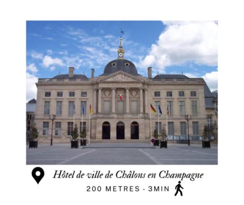 a large white building with flags in front of it at Appart complet - 2 à 4 personnes coeur de ville in Châlons-en-Champagne