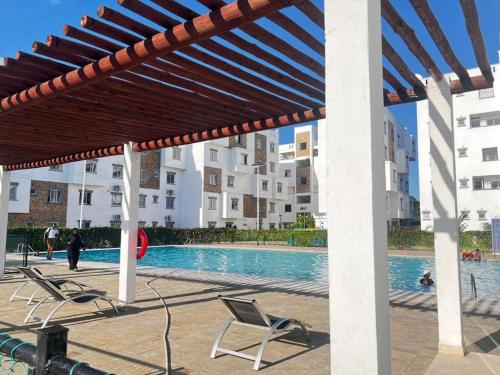 a patio with chairs and a swimming pool with buildings at Buxton Point Holiday Homes in Mombasa