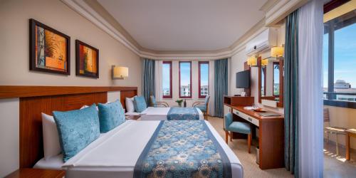 a hotel room with two beds and a desk at Villa Side Hotel in Side