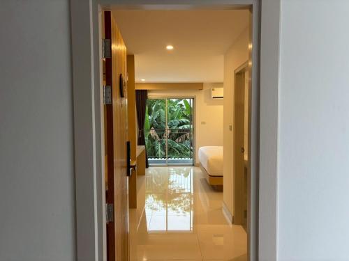 a hallway of a hotel with a bed and a room at Luna Resident in Ban Bang Phai