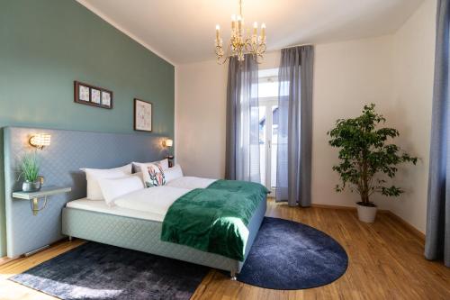 ein Schlafzimmer mit einem Bett und einem Kronleuchter in der Unterkunft Höllental heritage house - Zugspitzblick - 3 in Garmisch-Partenkirchen