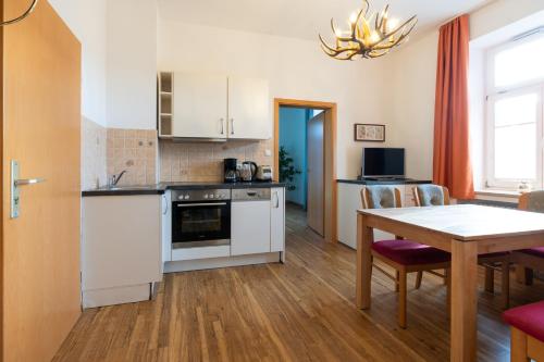 eine Küche mit Tisch und ein Esszimmer in der Unterkunft Höllental heritage house - Zugspitzblick - 3 in Garmisch-Partenkirchen