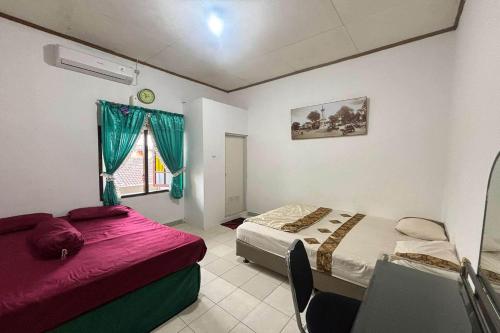 um quarto com duas camas e uma janela em OYO 94937 Garuda Homestay Syariah em Demangan