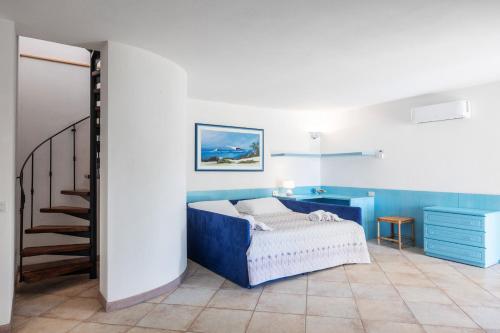 a bedroom with a blue bed and a staircase at Sardegna è - Beach Rooms LE in Olbia