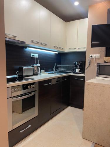 a kitchen with white cabinets and a stove top oven at Modern Apartment in the Heart of Vidin in Vidin