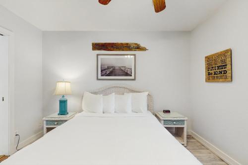 a bedroom with a large white bed with two tables at Neptunes Palace A1 in Saint George Island