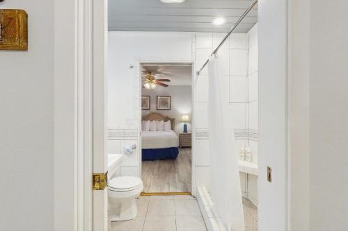 a bathroom with a toilet and a bedroom at Neptunes Palace A1 in Saint George Island