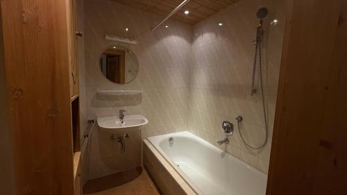 een badkamer met een bad en een wastafel en een ligbad bij Haus Sonnbichl Top 3 in Krimml