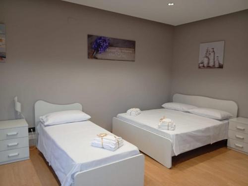 two beds in a room with white walls at House Le Treemme in Chiubbica