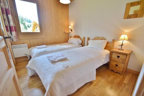 a bedroom with two beds and a window at Refuge Les Echelles E4 in Le Grand-Bornand