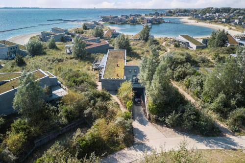 eine Luftansicht eines Hauses mit dem Meer dahinter in der Unterkunft Exclusive Duin Villa - 6p - Direct bij Natuur & Strand - Villa 70 in Ouddorp