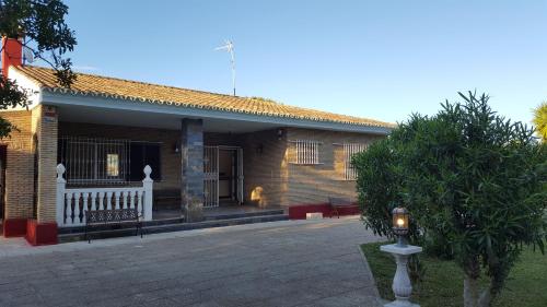un edificio de ladrillo con un banco delante de él en El Cortijo, en Chiclana de la Frontera