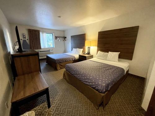a hotel room with two beds and a desk at SureStay by Best Western Prince Frederick in Prince Frederick