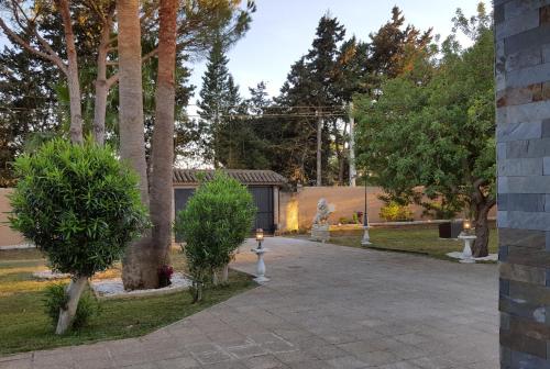 a walkway in a park with trees and a building at El Cortijo in Chiclana de la Frontera