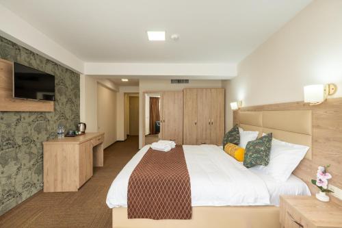 Una habitación de hotel con una cama grande y un televisor. en Hotel Somi Inn, en Tiflis