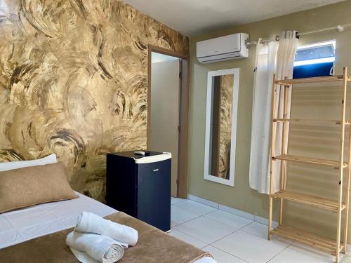 a bedroom with a bed and a stone wall at POUSADA AREIAS DE PAJUÇARA in Maceió