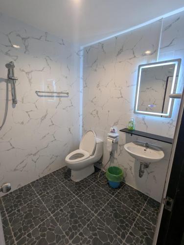 a bathroom with a toilet and a sink at Lamai Beachroad Apartment in Lamai