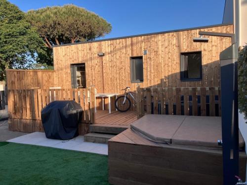 a wooden deck with a table and a fence at Le refuge sablais in Les Sables-dʼOlonne