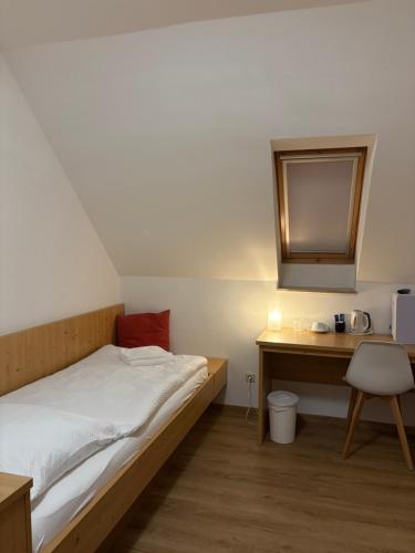 a bedroom with a bed and a desk and a mirror at Gasthof Wilhelm Tell bei Anna in Zirndorf