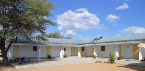 a large white building with a blue roof at steps Self-Catering Accommodation in Okakarara