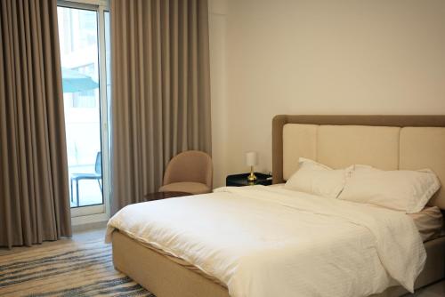 a bedroom with a large white bed and a balcony at Marjan Escape Studio in Dubai