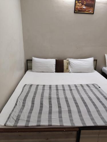 a bed with a striped mattress in a room at Swamy Residency in Vellore