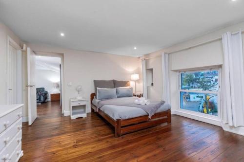 a bedroom with a bed and a large window at Quiet Victorian flat, Gloucester Road, fast wifi in Bristol