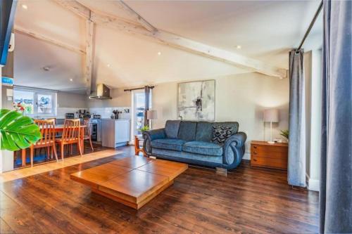 a living room with a blue couch and a table at Quiet Victorian flat, Gloucester Road, fast wifi in Bristol
