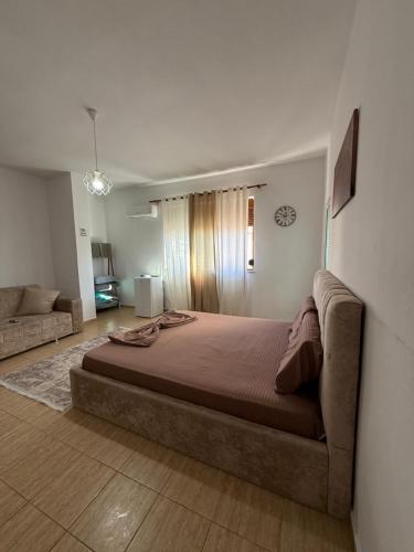a bedroom with a large bed and a couch at Koa Studio 2 in Korçë