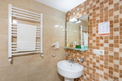 Un baño con lavabo, inodoro y espejo. en Hotel Somi Inn, en Tiflis