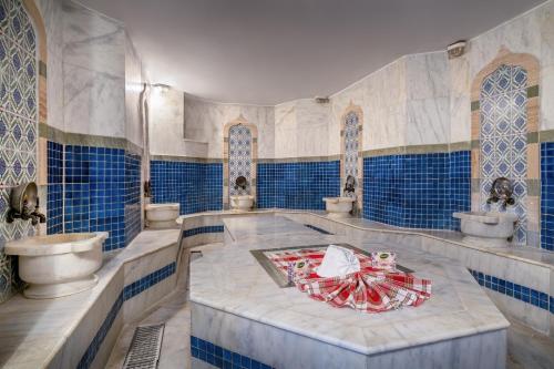 a bathroom with blue and white tiled walls and a table at Villa Side Hotel in Side