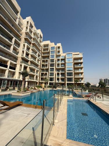 a large apartment building with a swimming pool in front of it at Marjan Escape Studio in Dubai