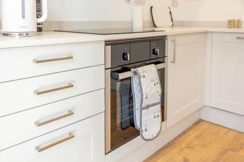 a kitchen with a dish towel hanging on the oven at Joyful Management - A Mordern Semi-Detached House with 3 bedroom in Manchester