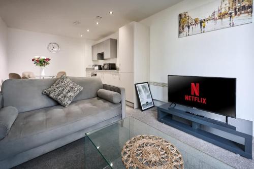 a living room with a couch and a flat screen tv at Joyful Management - Riverview 1 bedroom Apartment 10 min to City Centre in Manchester
