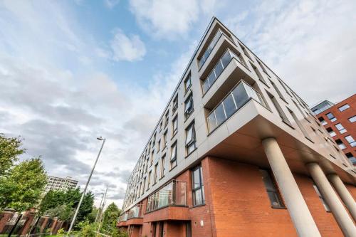 a large brick building with windows on a city street at Joyful Management - Riverview 1 bedroom Apartment 10 min to City Centre in Manchester